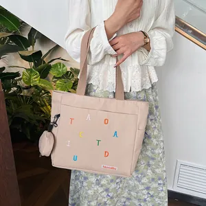Beige canvas tote bag with colorful embroidery and mini coin purse for daily commute