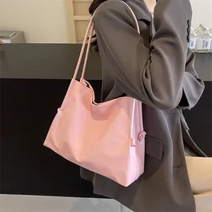 Detalle del bolso tote de cuero sintético rosa con correas finas y nudo decorativo