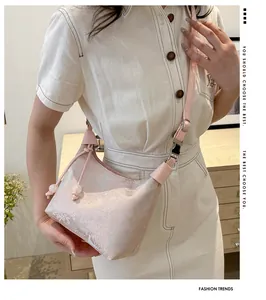 Close-up of pink jacquard fabric detail on a shoulder bag with elegant plant textures