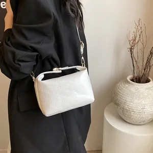 Detail of embossed rich rabbit lettering on white leather crossbody dumpling bag