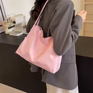 Vista lateral de un bolso tote rosa minimalista llevado por una modelo en interior