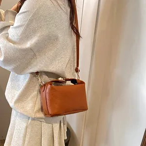 Brown leather crossbody bag with rich rabbit embossing and gold metal clasp closure