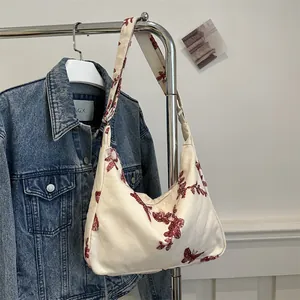 Detail of butterfly and floral embroidery on a vintage canvas underarm shoulder bag