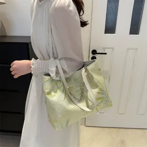 Detailed view of jacquard floral pattern on tote bag with white leather handles