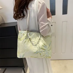 Detail of jacquard tote bag with bamboo leaf pattern and pearl flower chain handle