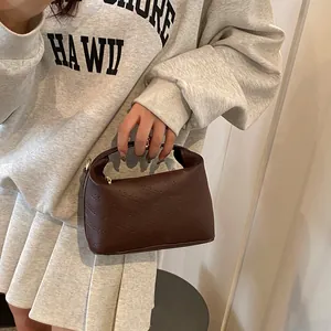 Detail of dark brown leather mini handbag with rich rabbit embossed pattern texture