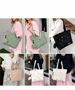 Detailed view of canvas tote bag with letter print and detachable coin purse for daily use