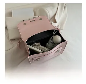 Interior view showing capacity of pink flap bag for phone, umbrella, and wallet