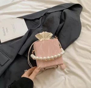Detail view of pink marble texture bag with elegant large pearl handle and drawstring
