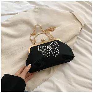 Détail du sac coquille noir avec motif papillon en perles et fermoir doré