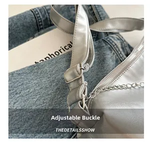 Detailed macro view of the silver metallic adjustable buckle and chain on the crossbody bag