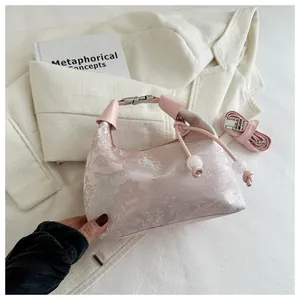 Detail of pink jacquard handbag featuring traditional Chinese landscape patterns and beads