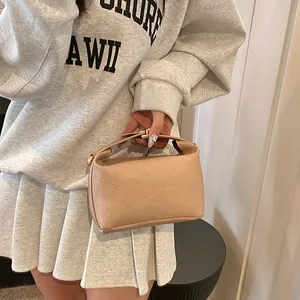 Detail showing apricot faux leather bag with rich rabbit embossed pattern and short handle
