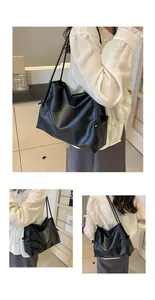 Detalle del bolso tote minimalista de piel suave negra con correas dobles y textura elegante