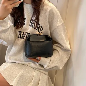 Close-up of black crossbody bag with rich rabbit embossed text and gold metal buckle