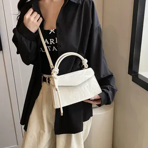 Détail du sac bandoulière blanc plissé avec poignée nouée sur un mannequin femme