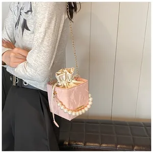 Detail of pink marble textured mini bucket bag with pearl handle and drawstring closure