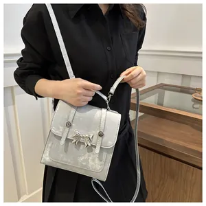Detail of silver metallic bag featuring a chrome butterfly buckle and cracked texture