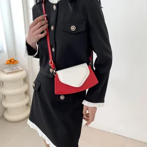 Detail of red and white crossbody bag with heart clasp and elegant pearl chain strap