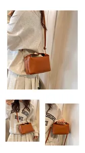 Detail of a brown crossbody bag featuring rich rabbit embossed pattern and adjustable strap