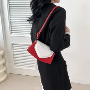 Detail view of a fashion crossbody bag with heart-shaped red and white contrast design