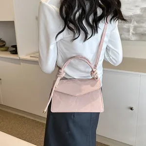 Détail du sac bandoulière rose plissé avec poignée à nœud et bandoulière réglable