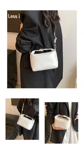 Detail view of white leather shoulder bag with rich rabbit embossed pattern and gold hardware