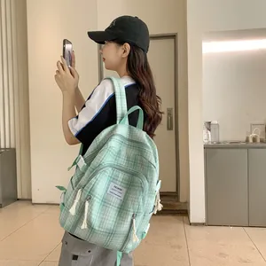 Detail eines hellgrünen karierten Leinenrucksacks mit gewebtem Reißverschlusszug