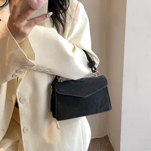 Détail du sac bandoulière noir plissé avec poignée nouée et anneaux dorés brillants