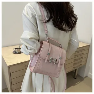 Detail of pink backpack featuring silver bow buckle and adjustable strap in lifestyle setting