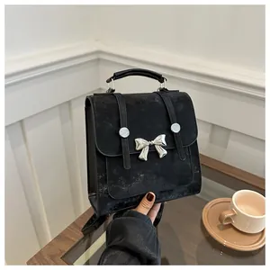 Close-up of black matte bag with a silver butterfly buckle in a lifestyle setting