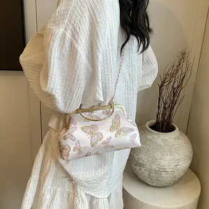 Detailed embroidery of pink and gold butterflies on a vintage satin clutch bag