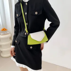 Detail of lime green and white crossbody bag with heart flap and pearl chain