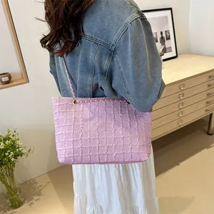 Pink tweed chain shoulder bag showing textured quilted pattern and metal strap detail