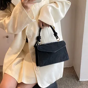 Détail d'un sac à main noir vintage avec texture plissée et poignée en corde torsadée