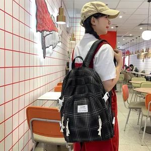 Detail des karierten Segeltuch-Rucksacks mit Reißverschlusstasche in einem Café-Ambiente