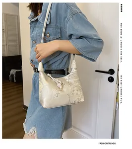 Detail of silk jacquard fabric with floral patterns on an elegant hobo shoulder bag