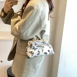Elegant white satin evening bag with butterfly patterns and gold metal top handle