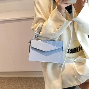 Détails du sac à main bleu clair avec texture plissée et nœuds élégants sur la poignée