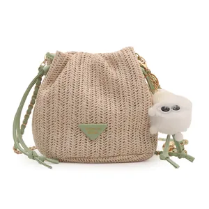 Contrast straw bucket bag with green leather trim and stylish metal chain strap