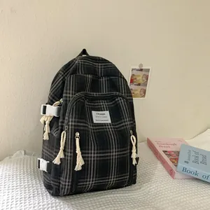 Detail des karierten Leinenrucksacks mit weißer Schnalle und Seil-Reißverschlüssen