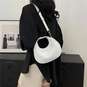 Detail of white snakeskin crescent bag with premium gold hardware and leather strap