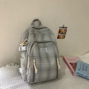 Detailansicht des grauen karierten Leinenrucksacks mit Seil-Reißverschluss und Label