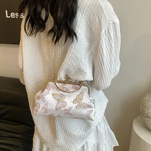 White satin vintage kiss-lock bag featuring pink butterfly embroidery and gold chain handle