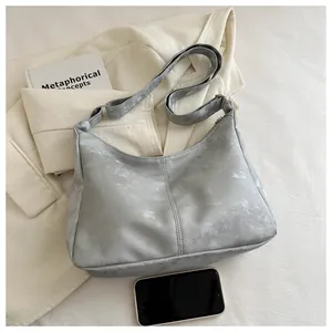 Close-up of silver hobo tote showing textured PU leather and spacious interior with phone