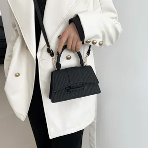 Détail d'un sac à main chic en cuir noir texturé avec boucle anneau et bandoulière