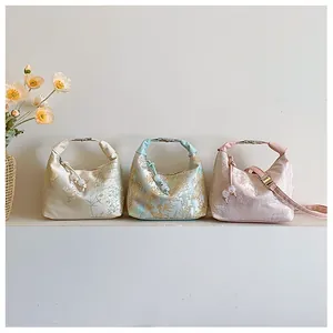Detailed trio of silk jacquard handbags with traditional floral patterns in soft colors