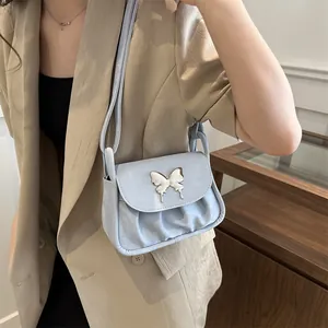 Detail einer hellblauen Plissee-Handtasche mit silbernem Schmetterlingsverschluss