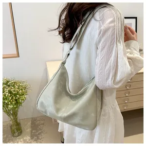 Sage green slouchy tote bag with a unique knot shoulder strap detail shown on a model