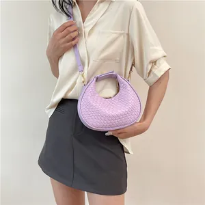 Detail showing lavender woven crescent bag texture and metal buckle on the shoulder strap